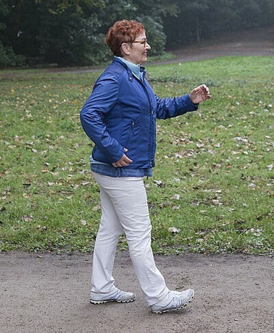 Ältere Frau läuft durch einen Park