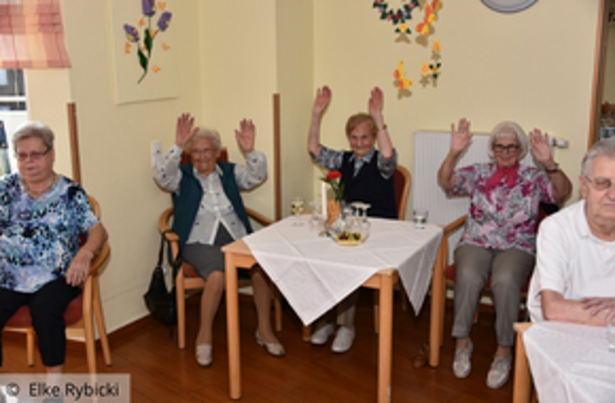 Tanztee: Seniorinnen und Senioren halten Arme hoch