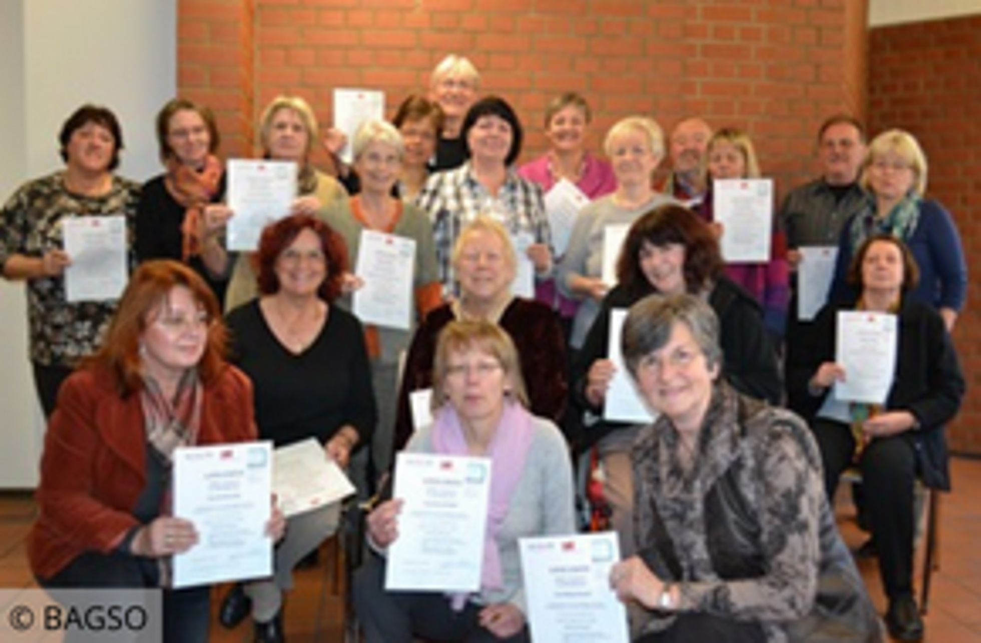 Gruppenfoto mit Personen, die Zertifikate in den Händen halten