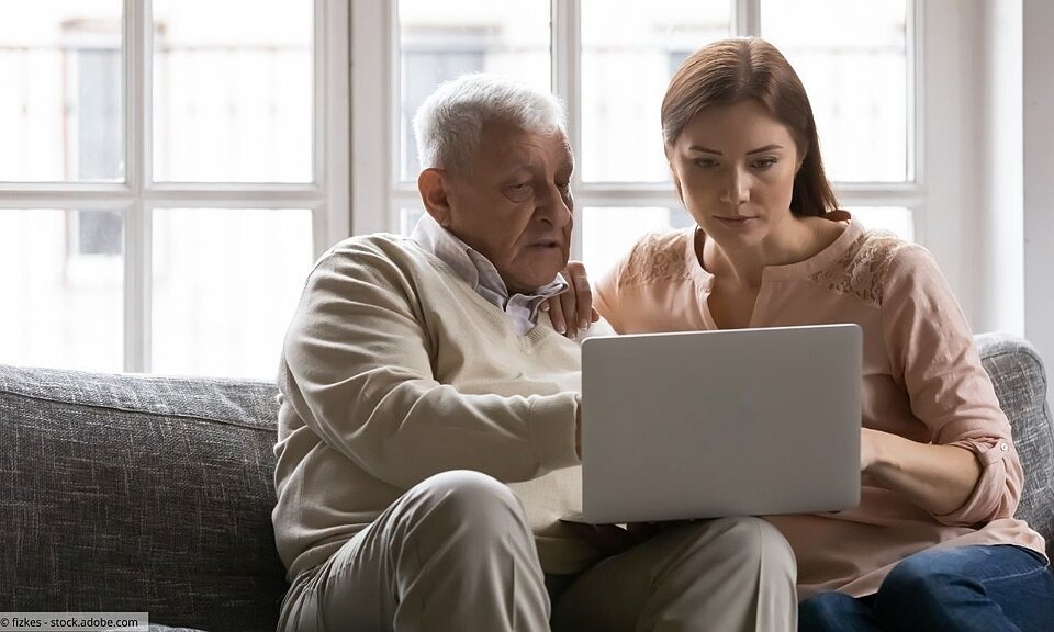 Großvater und erwachsene Enkelin mit Laptop