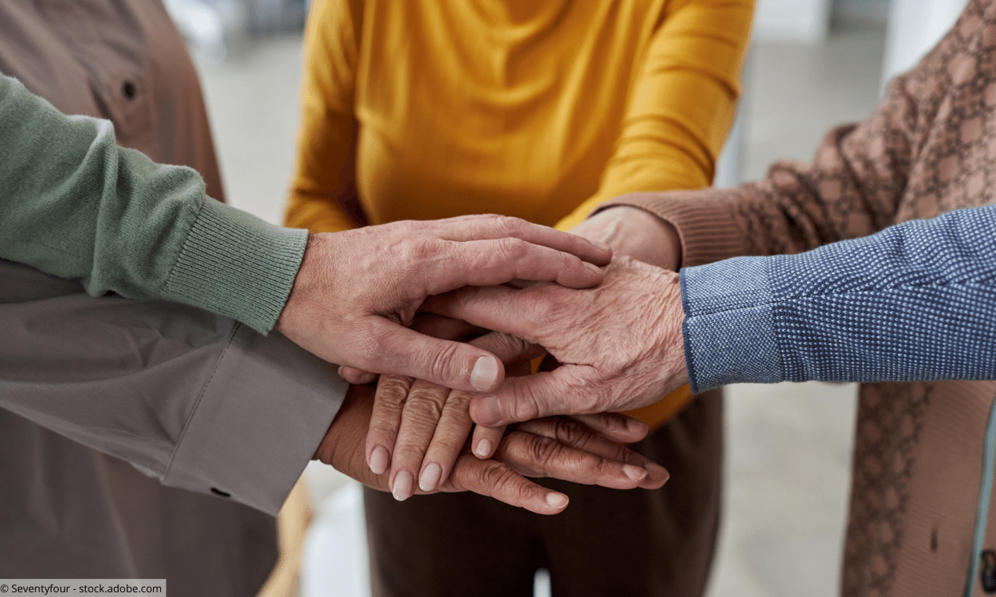 Seniorinnen und Senioren legen Hände aufeinander