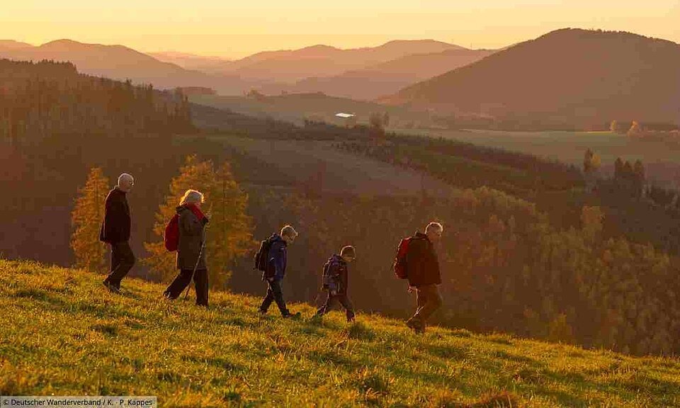 Gruppe von Wanderern läuft Berg hinunter