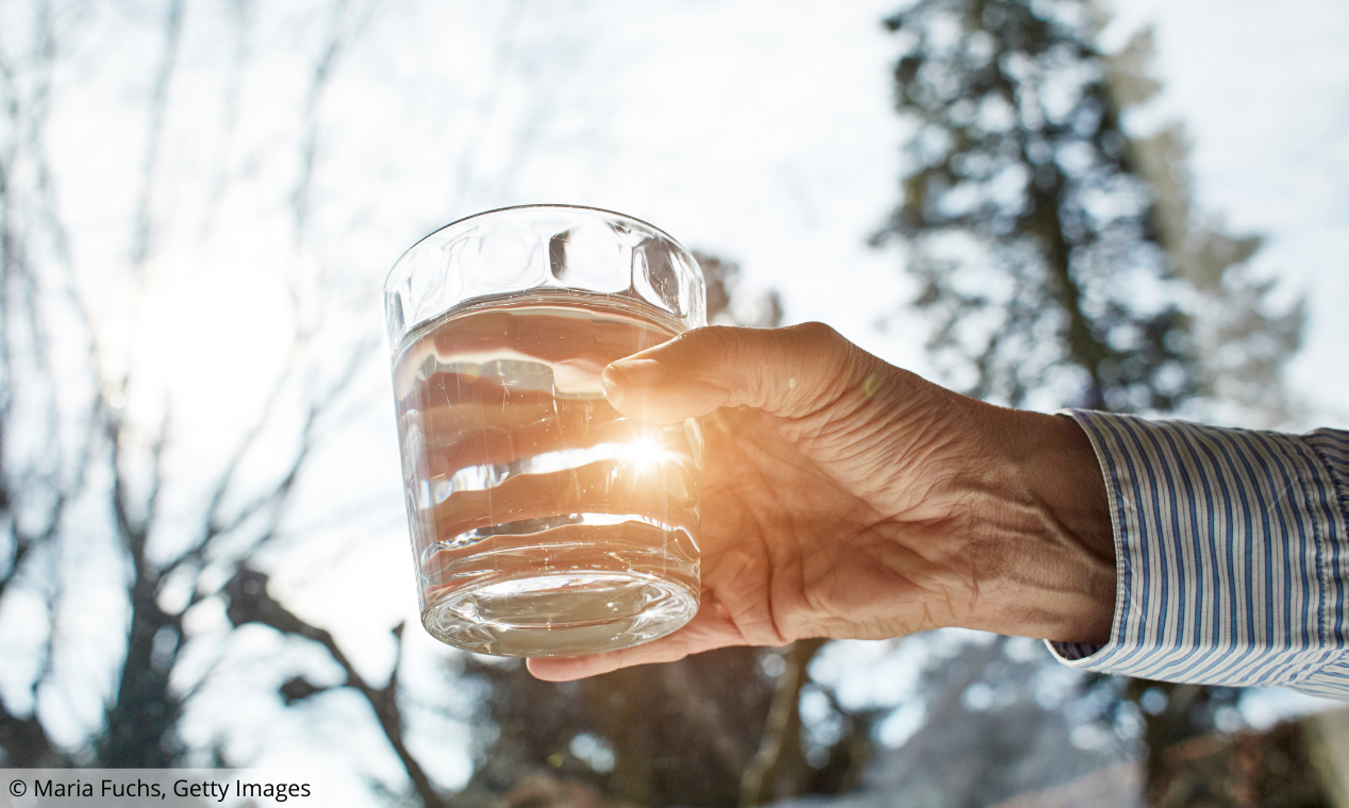 Hand hält Wasserglas