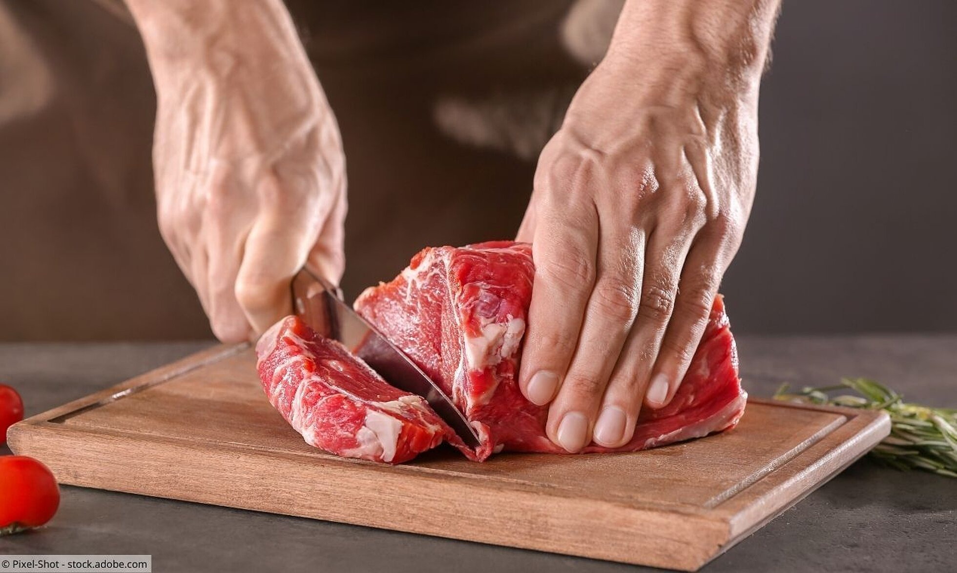 Nahaufnahme von Händen, die Fleisch schneiden