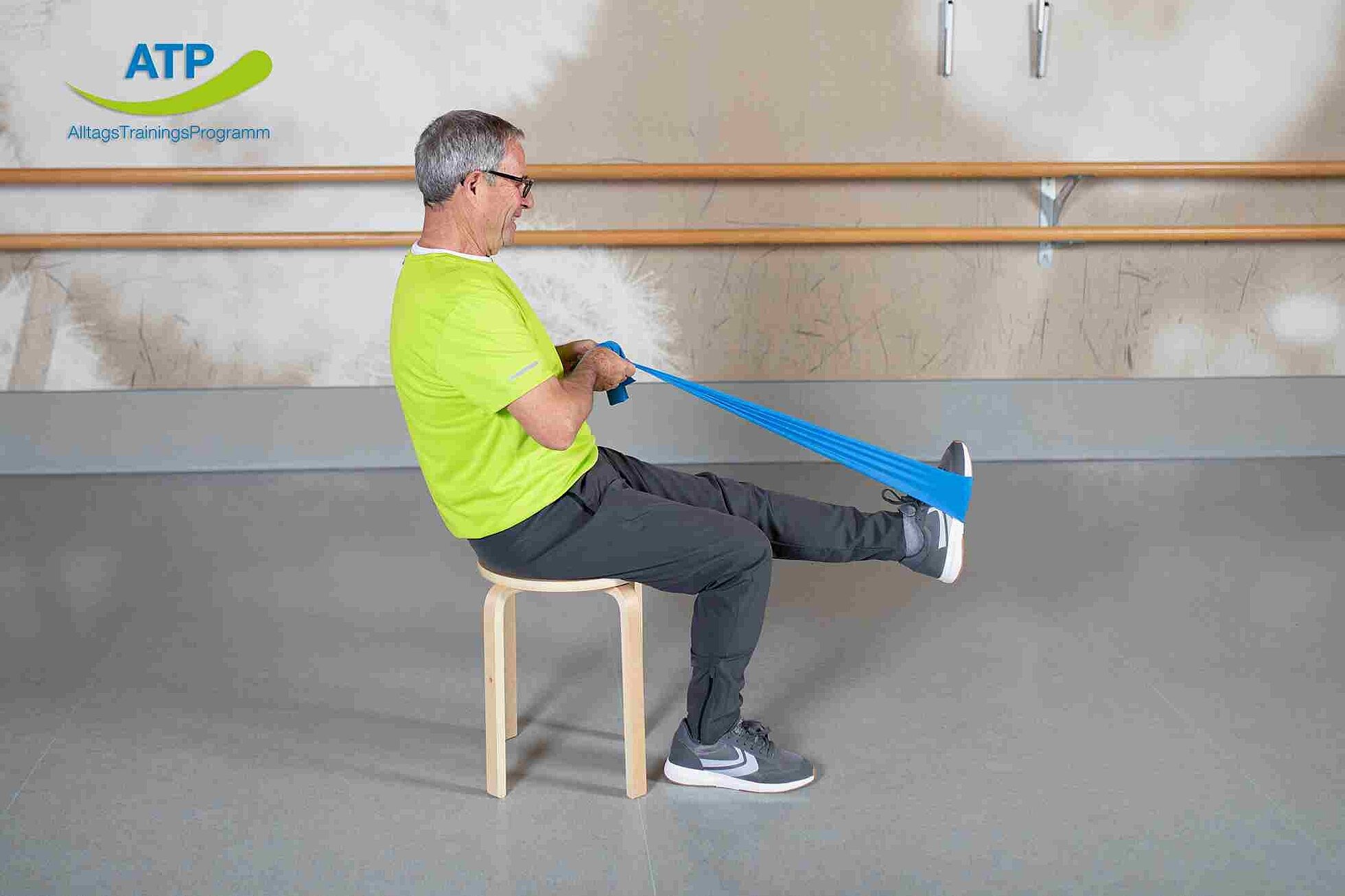 ATP-Dauerangebot Übung 1 Älterer Mann dehnt Oberschenkel im Sitzen