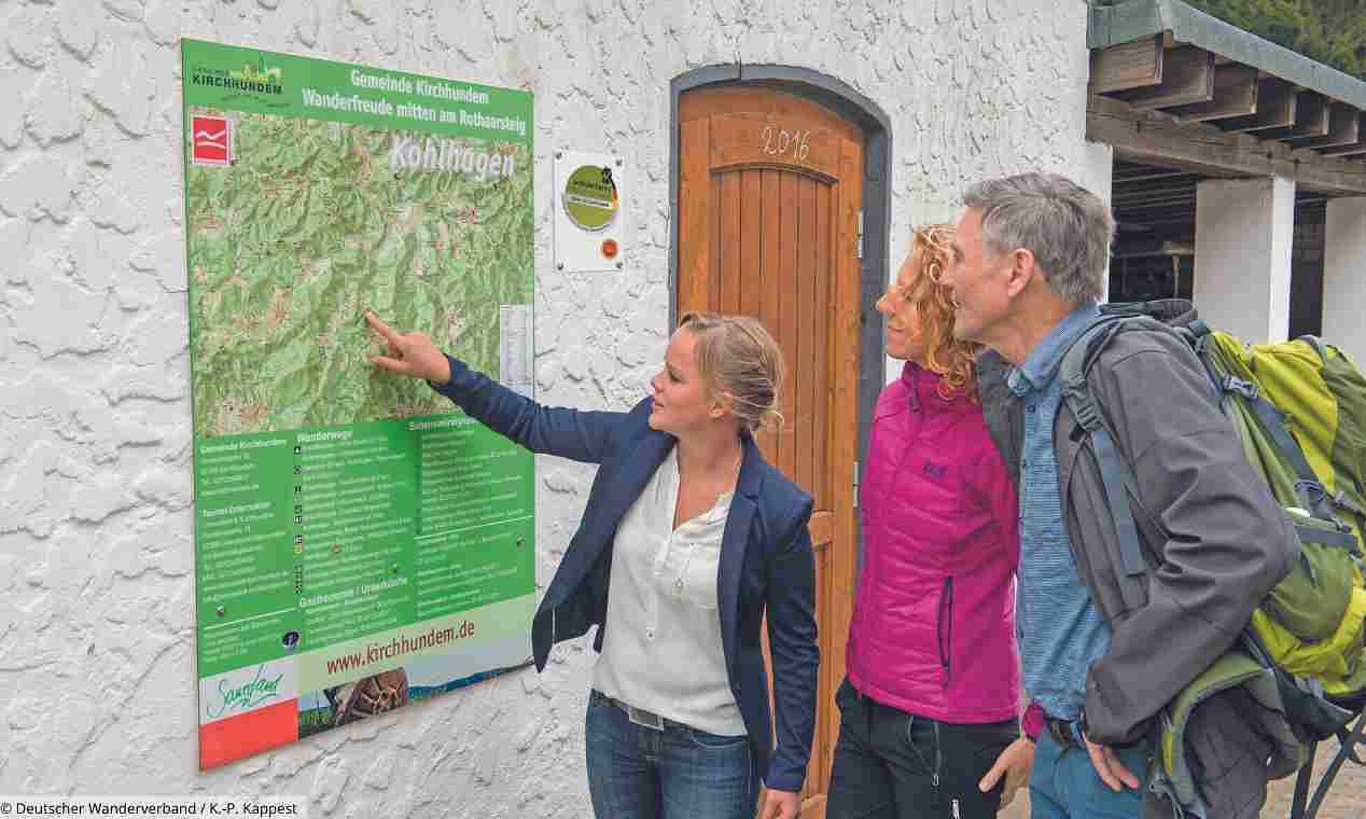 Wissenswertes rund ums Wandern - von A bis Z Frau mit zwei Wanderern vor Karte