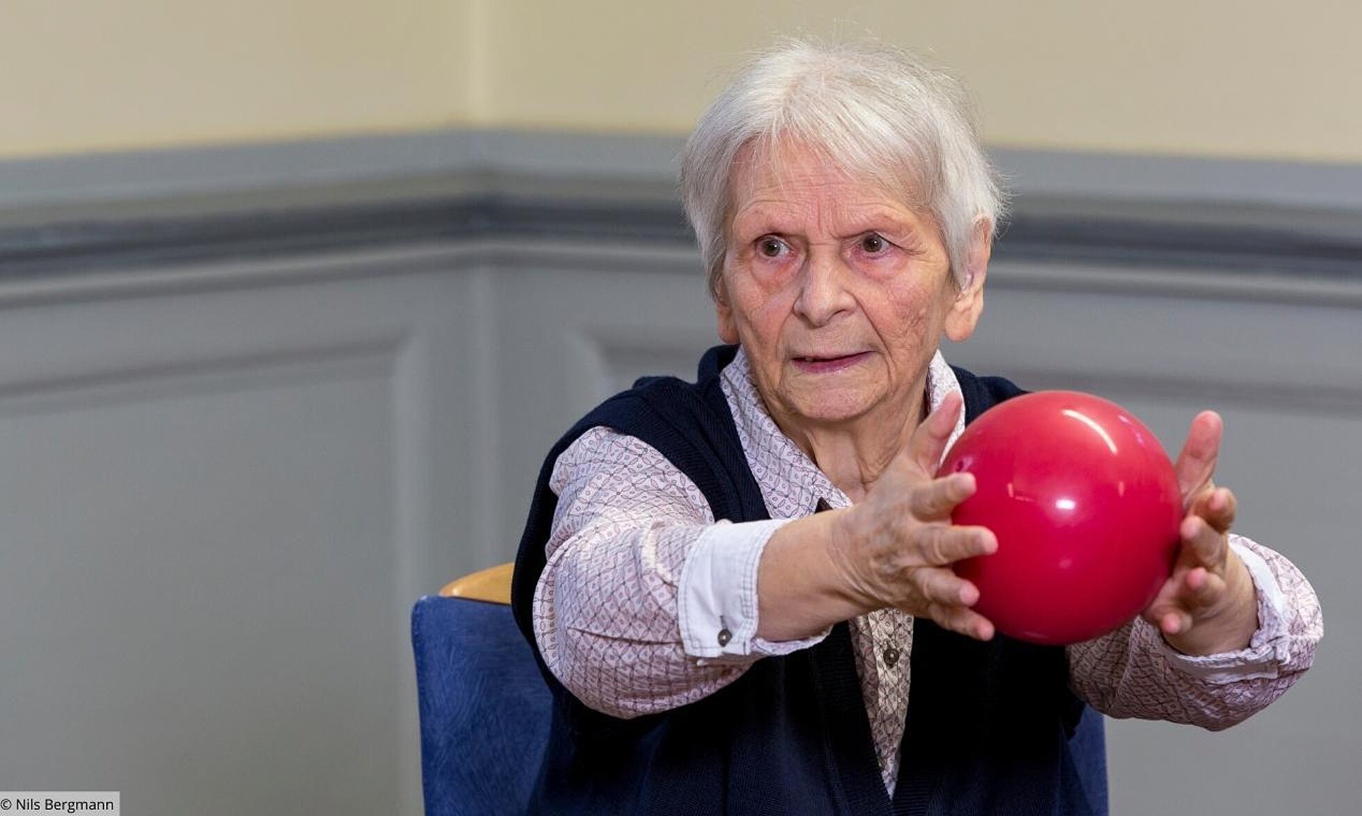 ältere Frau mit Ball zwischen den Händen