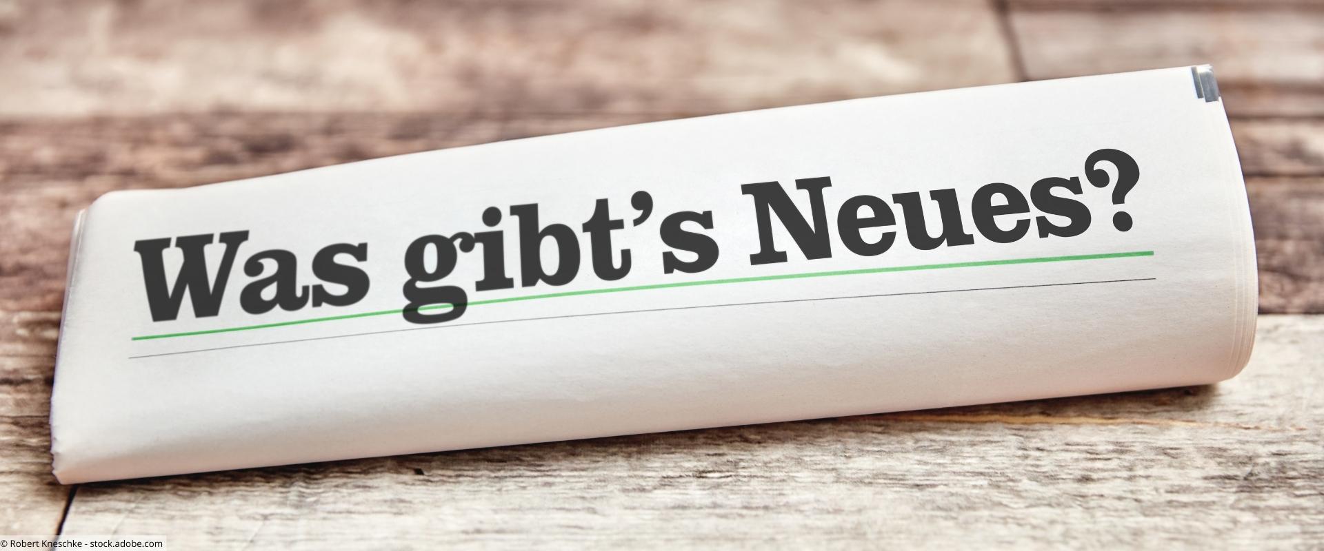Gerollte Zeitung mit der Aufschrift "Was gibt's Neues?"