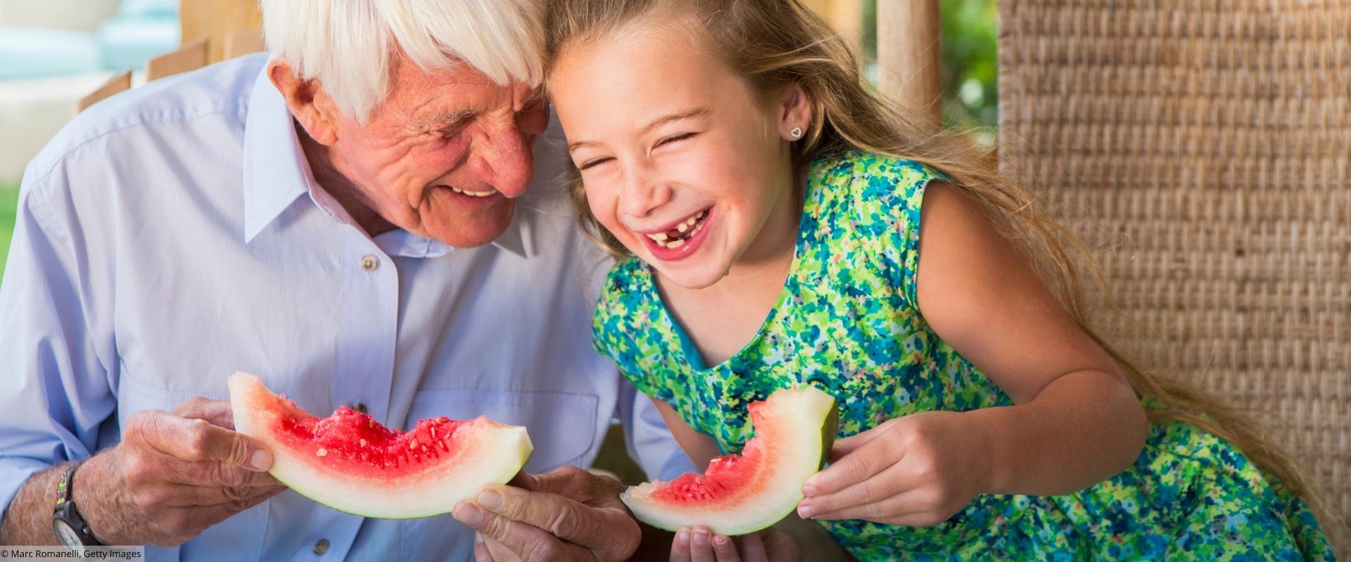 Großvater und Enkelin essen Melone